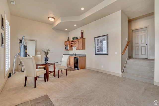 living area with baseboards, wet bar, recessed lighting, light carpet, and beverage cooler