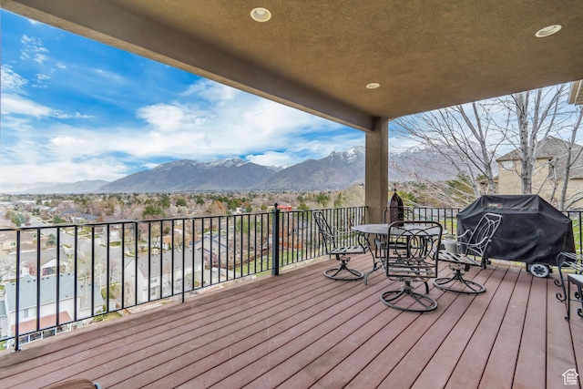 deck featuring a mountain view, outdoor dining area, and area for grilling