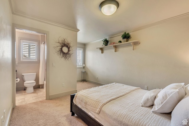 bedroom featuring baseboards, connected bathroom, crown molding, and light carpet