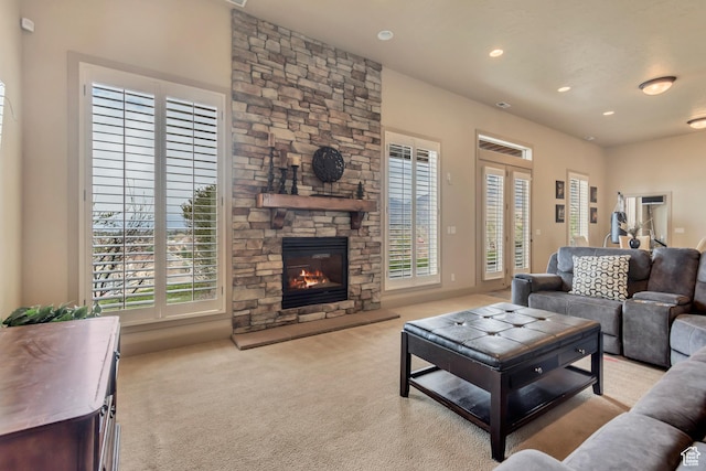 living room with recessed lighting, carpet, and a stone fireplace