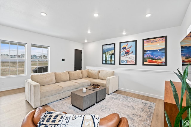 living area featuring light wood finished floors, baseboards, and recessed lighting