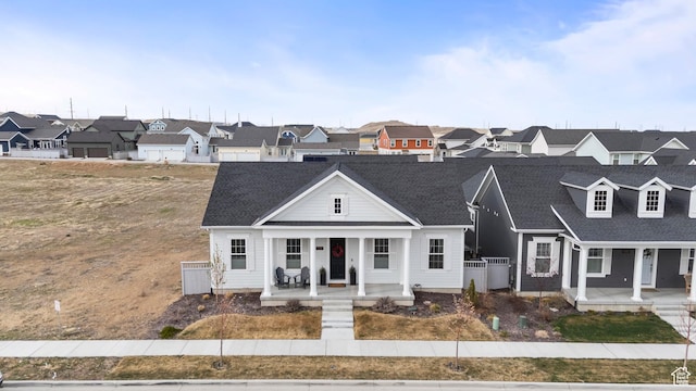 view of front of house featuring a porch, roof with shingles, and a residential view