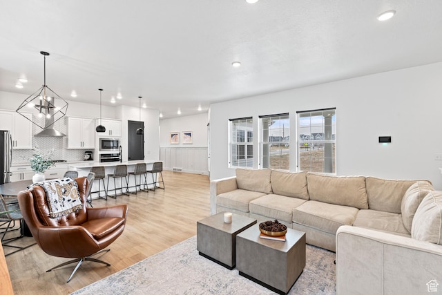 living room with wainscoting, visible vents, light wood-style floors, and recessed lighting