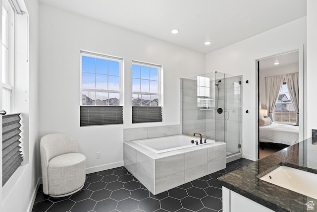 bathroom featuring a bath, a shower stall, tile patterned floors, vanity, and ensuite bath