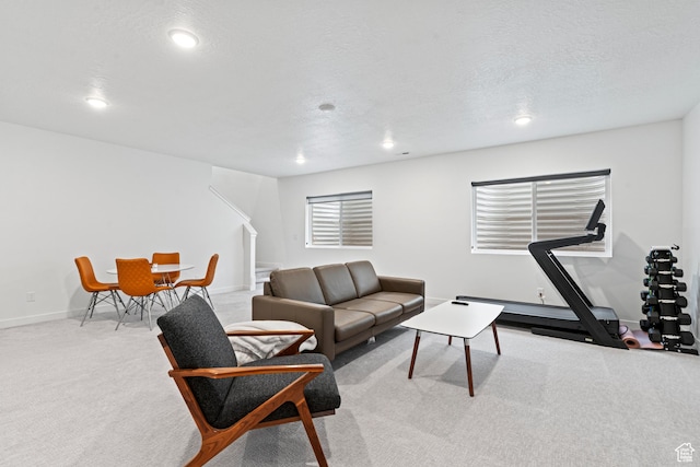 living area with a textured ceiling, baseboards, recessed lighting, stairway, and carpet floors