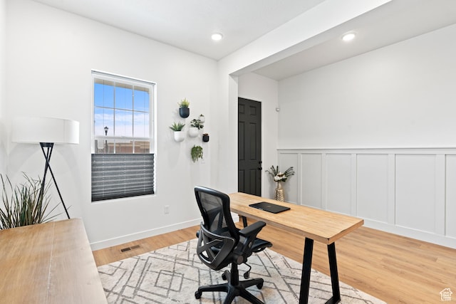 home office with a decorative wall, recessed lighting, a wainscoted wall, and wood finished floors