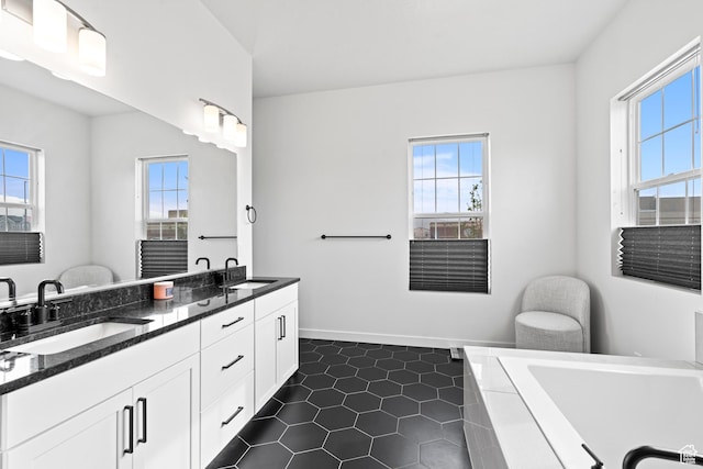 full bathroom featuring a relaxing tiled tub, a sink, and plenty of natural light