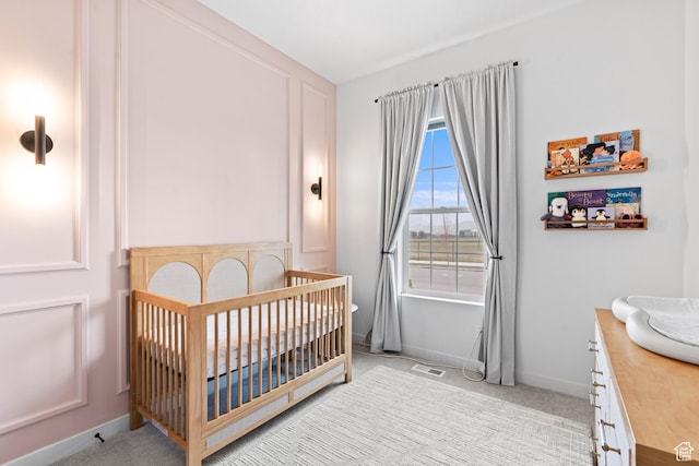 bedroom with light carpet, baseboards, visible vents, and a nursery area