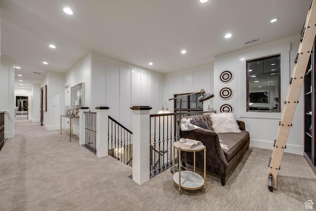 interior space with an upstairs landing, visible vents, recessed lighting, and light carpet