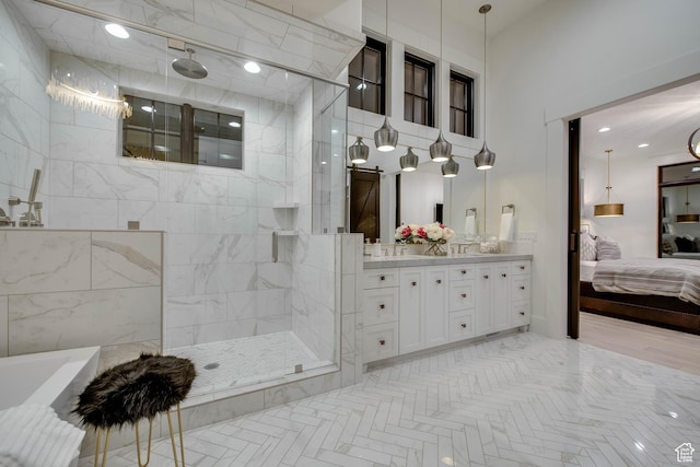 bathroom with a washtub, vanity, a walk in shower, and ensuite bath
