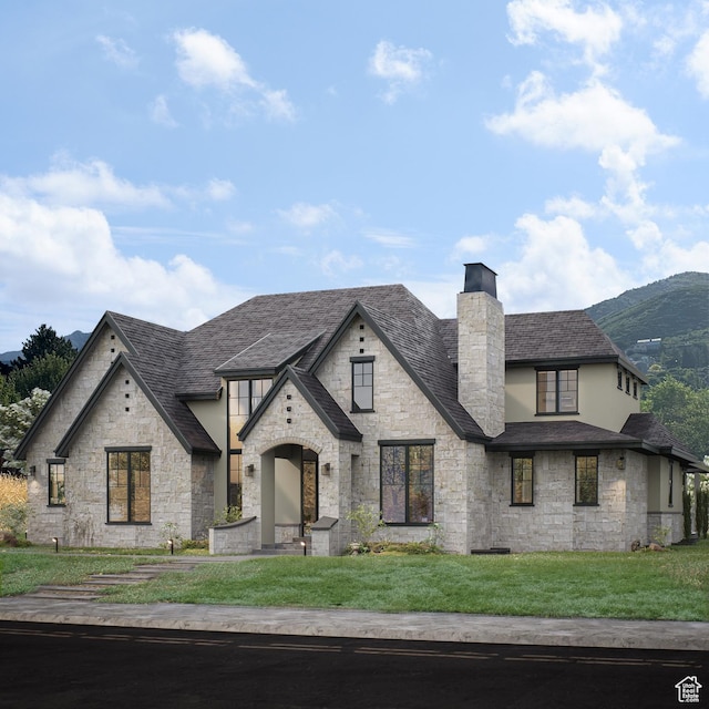 view of front of house with stone siding, a chimney, stucco siding, a front lawn, and a shingled roof