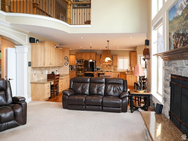 2524 E 700 S, Springville, UT 84663 - carpeted living area featuring built in desk, decorative columns, a high ceiling, arched walkways, and a stone fireplace