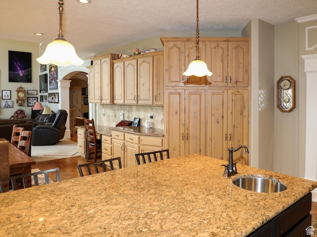 2524 E 700 S, Springville, UT 84663 - kitchen with light stone countertops, arched walkways, a sink, backsplash, and light brown cabinetry
