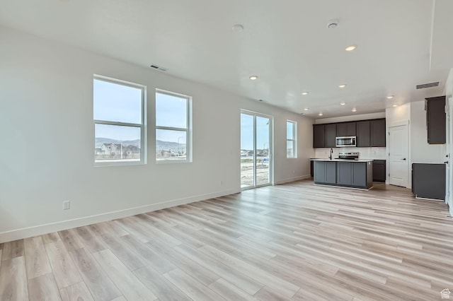 unfurnished living room featuring visible vents, baseboards, recessed lighting, and light wood-style floors
