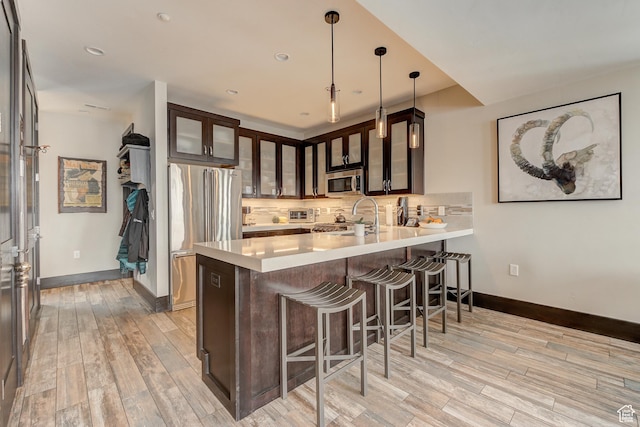 3676 Blackstone Dr, Park City, UT 84098 - kitchen with decorative backsplash, light countertops, a peninsula, and appliances with stainless steel finishes