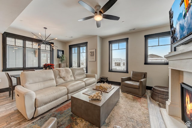 3676 Blackstone Dr, Park City, UT 84098 - living room with visible vents, ceiling fan with notable chandelier, a fireplace, and wood finished floors