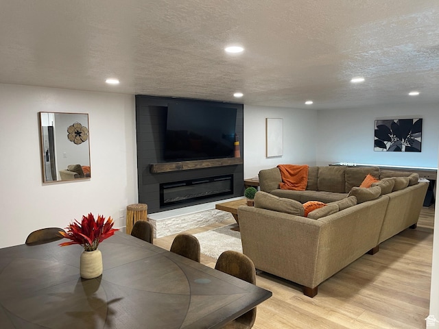 3444 S 1100 E, Millcreek, UT 84106 - living room with a fireplace, light wood-style flooring, recessed lighting, and a textured ceiling