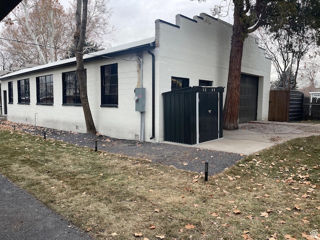 3444 S 1100 E, Millcreek, UT 84106 - view of property exterior with concrete block siding, driveway, a garage, and fence