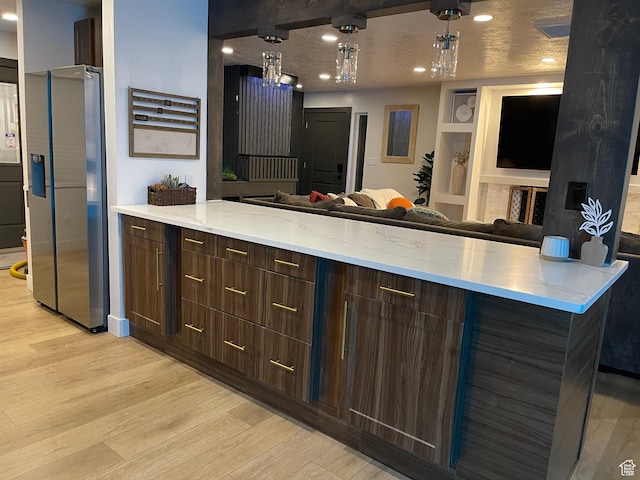 3444 S 1100 E, Millcreek, UT 84106 - kitchen with stainless steel fridge, a peninsula, light wood finished floors, light stone counters, and open floor plan
