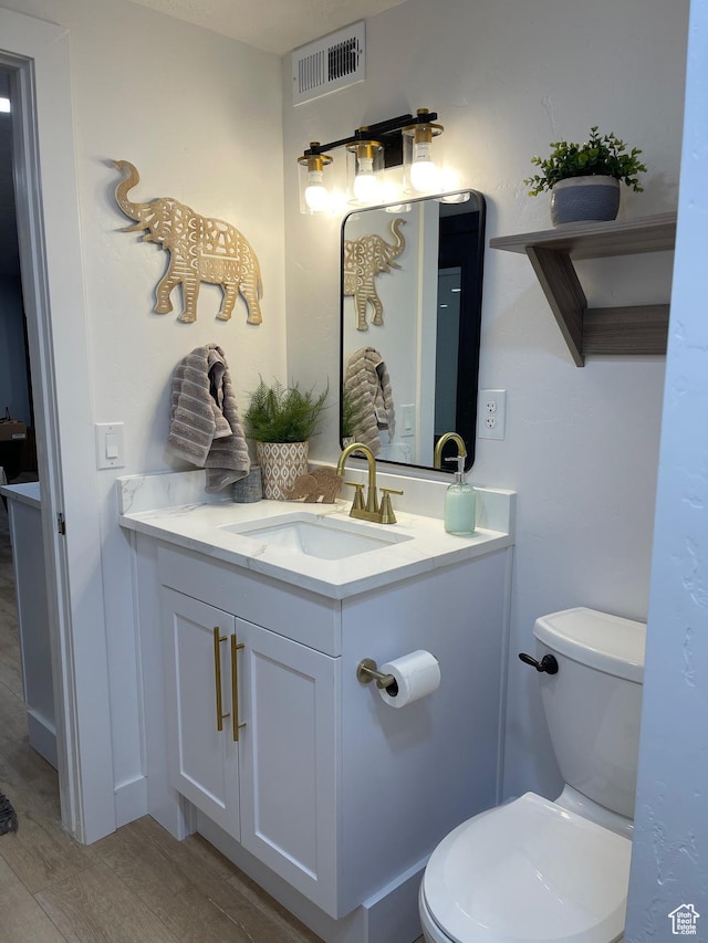 3444 S 1100 E, Millcreek, UT 84106 - bathroom with visible vents, toilet, vanity, and wood finished floors
