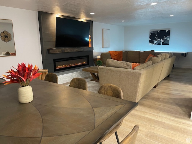 3444 S 1100 E, Millcreek, UT 84106 - living area featuring light wood-type flooring, a fireplace, recessed lighting, and a textured ceiling