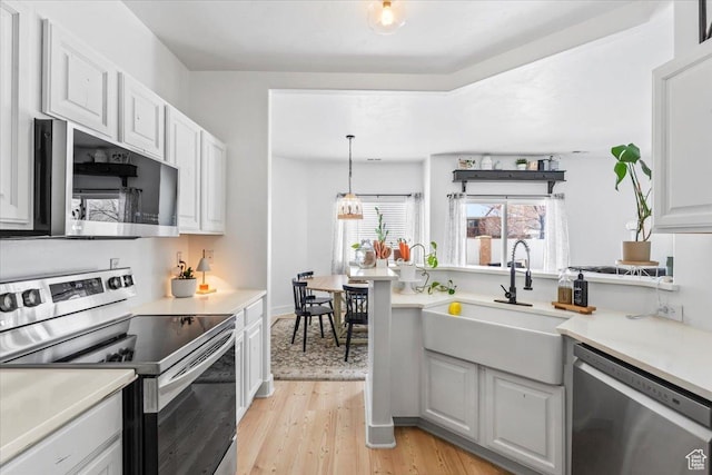 8464 S Ivy Springs Ln, West Jordan, UT 84081 - kitchen with light countertops, a sink, appliances with stainless steel finishes, light wood-type flooring, and white cabinets