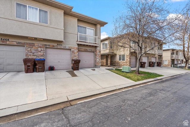 8464 S Ivy Springs Ln, West Jordan, UT 84081 - view of property featuring stone siding, concrete driveway, cooling unit, stucco siding, and an attached garage