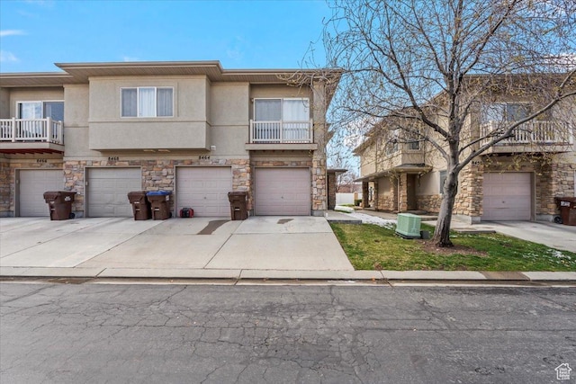 8464 S Ivy Springs Ln, West Jordan, UT 84081 - townhome / multi-family property featuring driveway, stone siding, central air condition unit, stucco siding, and a garage