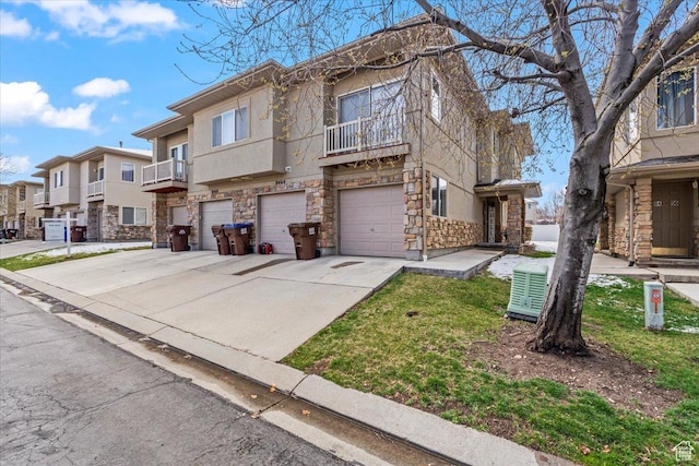 view of property featuring stucco siding, stone siding, a residential view, driveway, and a garage