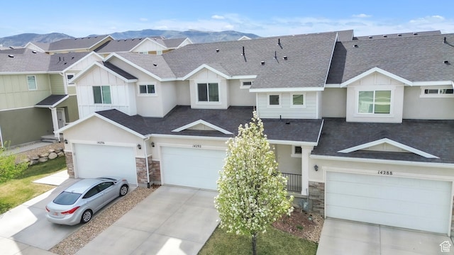 14292 S Autumn Path Ln W, Riverton, UT 84096 - view of property with board and batten siding, driveway, a mountain view, a shingled roof, and stone siding