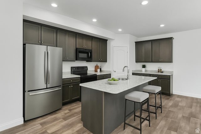 14292 S Autumn Path Ln W, Riverton, UT 84096 - kitchen with a kitchen breakfast bar, a sink, light countertops, black appliances, and light wood-style flooring