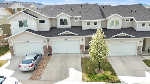 14292 S Autumn Path Ln W, Riverton, UT 84096 - townhome / multi-family property featuring concrete driveway, board and batten siding, a shingled roof, and stone siding