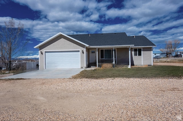 ranch-style home with a shingled roof, driveway, stucco siding, and an attached garage
