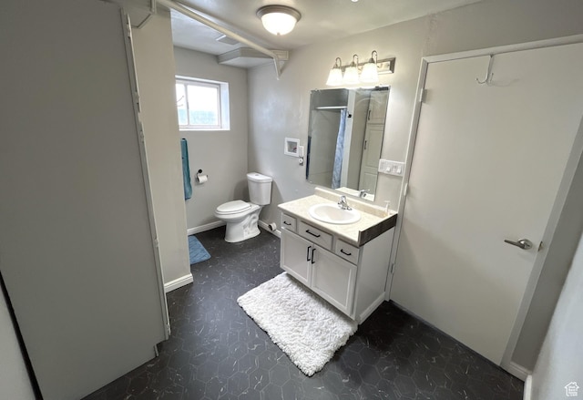 bathroom with baseboards, toilet, tile patterned floors, and vanity