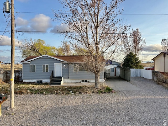 view of front facade with driveway, fence, and entry steps