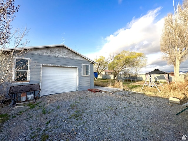 garage featuring driveway and a trampoline