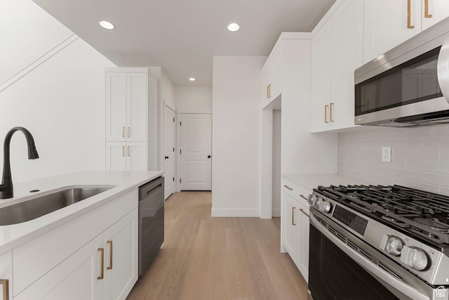 518 W Olive Ln, St George, UT 84790 - kitchen featuring appliances with stainless steel finishes, tasteful backsplash, light countertops, light wood-style floors, and white cabinetry