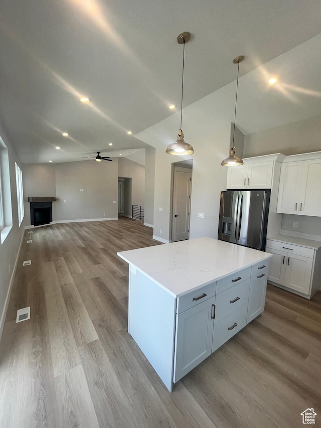 335 E 340 S, Kamas, UT 84036 - kitchen featuring stainless steel fridge with ice dispenser, visible vents, white cabinetry, and a fireplace