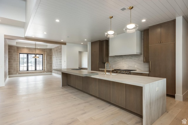 13926 S Jarvie Ln E, Draper, UT 84020 - kitchen with stainless steel gas cooktop, wooden ceiling, backsplash, light wood finished floors, and custom exhaust hood
