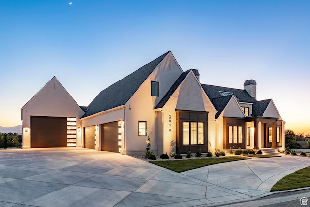 13926 S Jarvie Ln E, Draper, UT 84020 - view of front facade with driveway, a chimney, an attached garage, stucco siding, and roof with shingles
