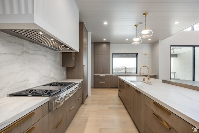 13926 S Jarvie Ln E, Draper, UT 84020 - kitchen featuring stainless steel gas cooktop, custom range hood, a sink, light wood-style flooring, and modern cabinets