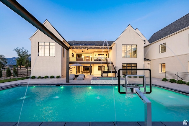13926 S Jarvie Ln E, Draper, UT 84020 - rear view of house featuring stairway, a patio, a pool with connected hot tub, a balcony, and stucco siding