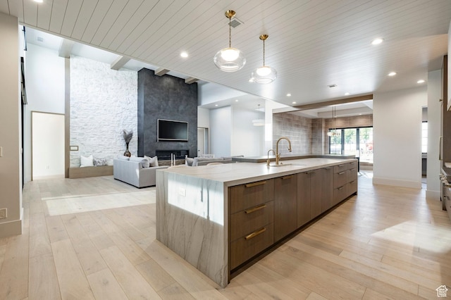 13926 S Jarvie Ln E, Draper, UT 84020 - kitchen with modern cabinets, open floor plan, a large island, light wood-type flooring, and light stone counters