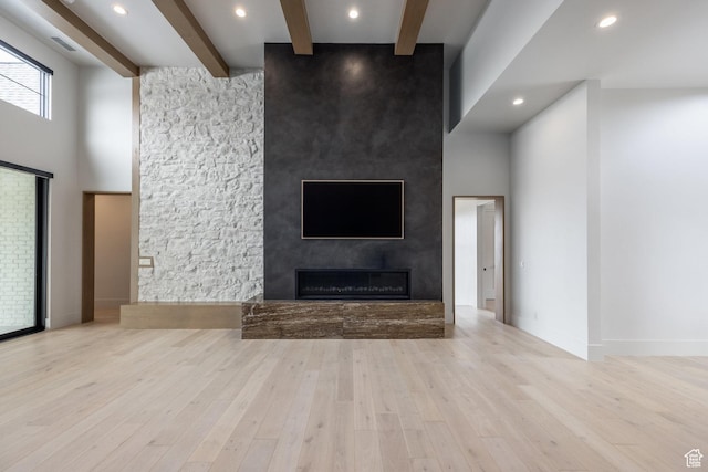 13926 S Jarvie Ln E, Draper, UT 84020 - unfurnished living room featuring a towering ceiling, beamed ceiling, a fireplace, and wood finished floors