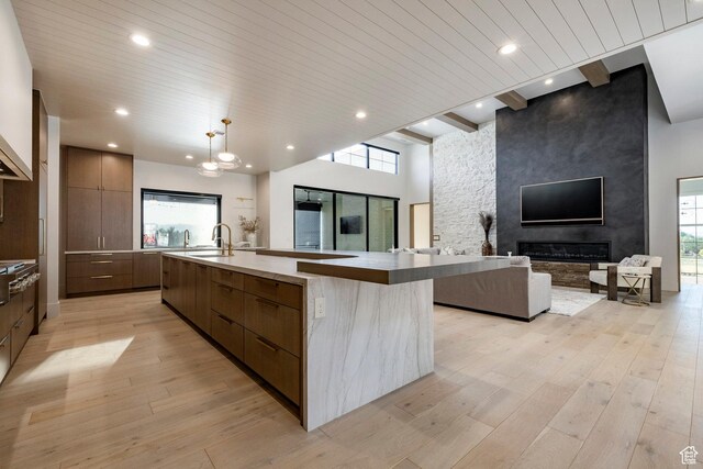 13926 S Jarvie Ln E, Draper, UT 84020 - kitchen with modern cabinets, open floor plan, a large island, a sink, and light wood-type flooring