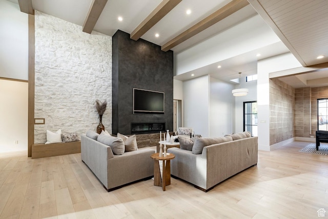 13926 S Jarvie Ln E, Draper, UT 84020 - living area with beamed ceiling, light wood-type flooring, a towering ceiling, a large fireplace, and baseboards