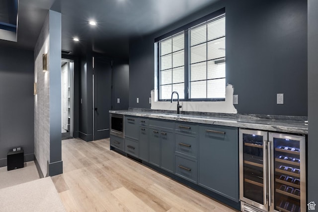 13926 S Jarvie Ln E, Draper, UT 84020 - kitchen with gray cabinetry, a sink, stone counters, light wood-style floors, and beverage cooler
