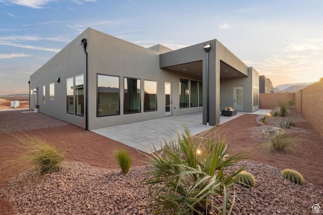 121 E Terrace Ln, Ivins, UT 84738 - back of house at dusk featuring a patio, a fenced backyard, and stucco siding