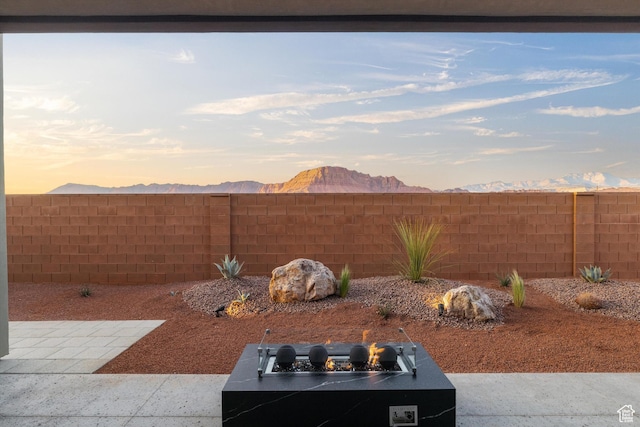121 E Terrace Ln, Ivins, UT 84738 - yard at dusk with a fenced backyard, a fire pit, and a mountain view