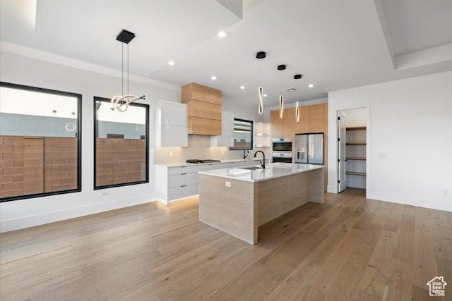 121 E Terrace Ln, Ivins, UT 84738 - kitchen with modern cabinets, stainless steel refrigerator with ice dispenser, an island with sink, and light countertops